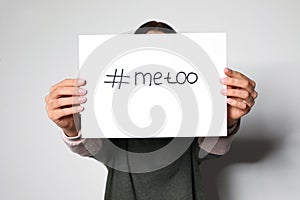 Young woman holding  METOO card against background