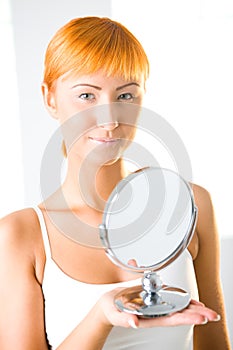 Young woman holding mirror