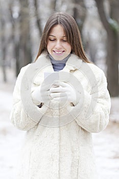 Young woman holding mobile phone and typing messages