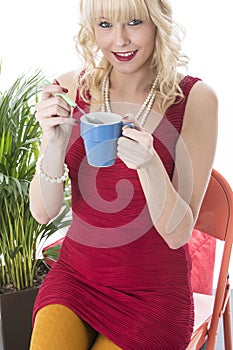 Young Woman Holding Mug of Coffee with Spoon