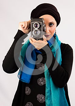 Young Woman holding old camera in hijab and colorful scarf