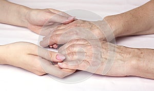 A young woman holding an older womans hands