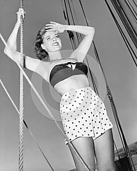 Young woman holding onto the ropes of an sail ship