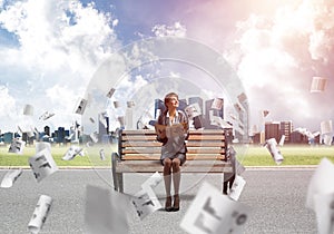 Young woman holding open book on wooden bench