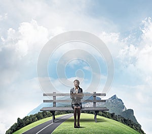 Young woman holding open book on wooden