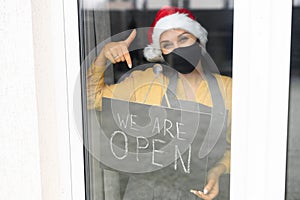 Young woman holding open sign in cafe