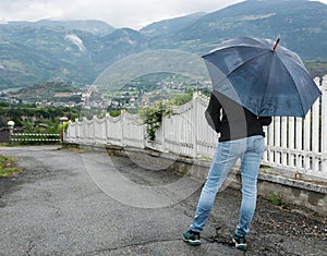 Young woman holding opened umbrella