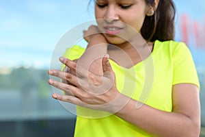 Young woman holding painful elbow