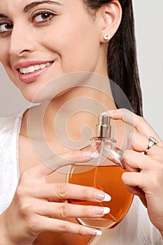 Young woman holding perfume bottle