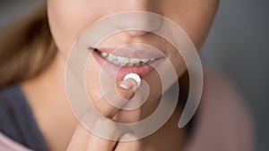 Young woman holding pill take meds, close up view