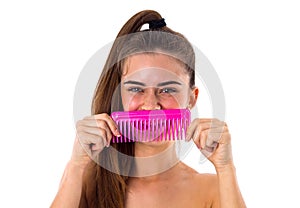 Young woman holding pink hair brush