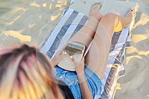 Young woman holding play thumb piano or kalimba musical instrument