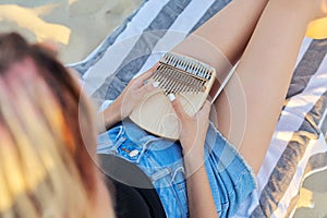 Young woman holding play thumb piano or kalimba musical instrument