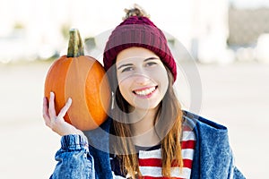 Young woman holding a pumpkin