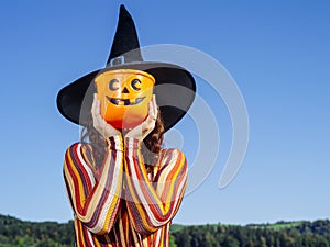 Young woman holding pumpkin bucket for Halloween