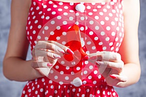 Young woman holding red aids ribbon