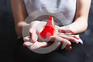 Young woman holding red aids ribbon