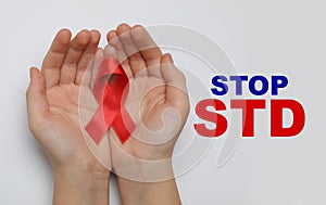 Young woman holding red awareness ribbon on white background, top view. Stop STD