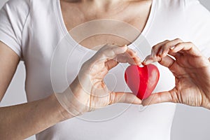 Young woman holding red heart, health insurance, donation, love concept
