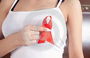 Young woman holding red ribbon HIV. AIDS. Healthcare and medicine