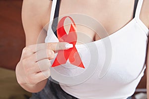 Young woman holding red ribbon HIV. AIDS. Healthcare and medicine