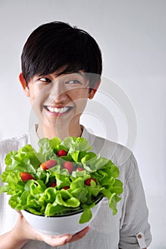 Young Woman Holding Salad Bowl Looking Beside