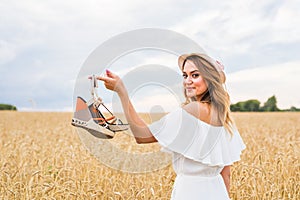 Young woman holding a shoe - sale, consumerism and people concept