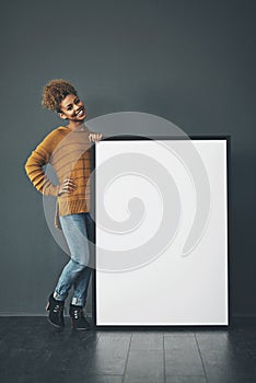 Young woman holding and showing an empty or blank sign for voicing an idea or advertisement announcement. Happy, excited photo