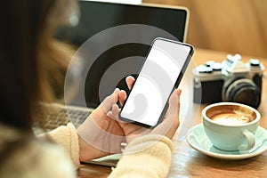 Young woman holding smart phone with empty display.