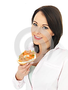 Young Woman holding Smoked Salmon and Cream Cheese Bagel