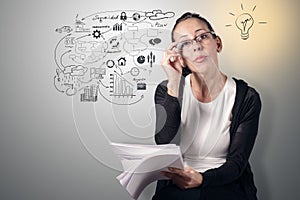 Young woman holding some papers and putting her glasses on