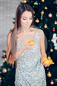 Young woman holding sweet mandarin, orange mood, diet and New year concept