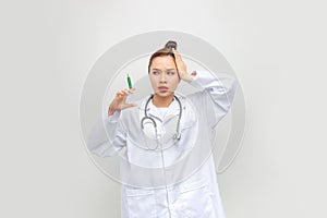 Young woman holding syringe stressed and frustrated with hand on head, surprised and angry face