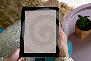 Young woman holding a tablet in her hands, close-up, space for text and advertising photo