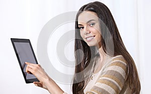 Mujer joven posesión muestra dedo sobre el pantalla mientras mira en blanco 