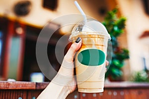 Young woman holding take away coffee cup.