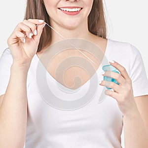 Young woman holding teeth floss. Dental health care concept. Beauty smiling face