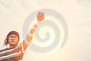 Young woman holding and throw alarm clock to the sky