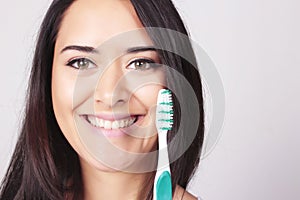 Young woman holding a tooth brush, isolated over white background