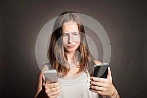 Young woman holding two cellulars photo