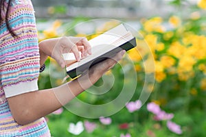 Young woman holding up a Bible to read because she wants to learn the teachings of God from the Bible with faith and faith in God