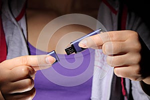 A young woman holding a USB flash memory stick