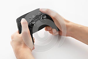 Young woman holding video game controller on white background