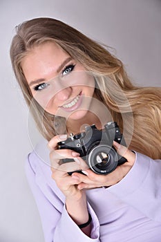 Young woman holding vintage camera in her hand