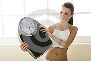 Young woman holding weight scale