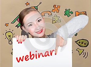Young woman holding whiteboard with writing word: webinar. Technology, internet, business and marketing.