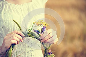 Young woman holding wreath of flowers