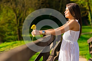 young woman holding yellow flowers