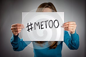 A young woman holds a banner with the inscription  metoo in front of he