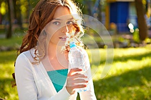 Young woman holds bottle of mineral water.